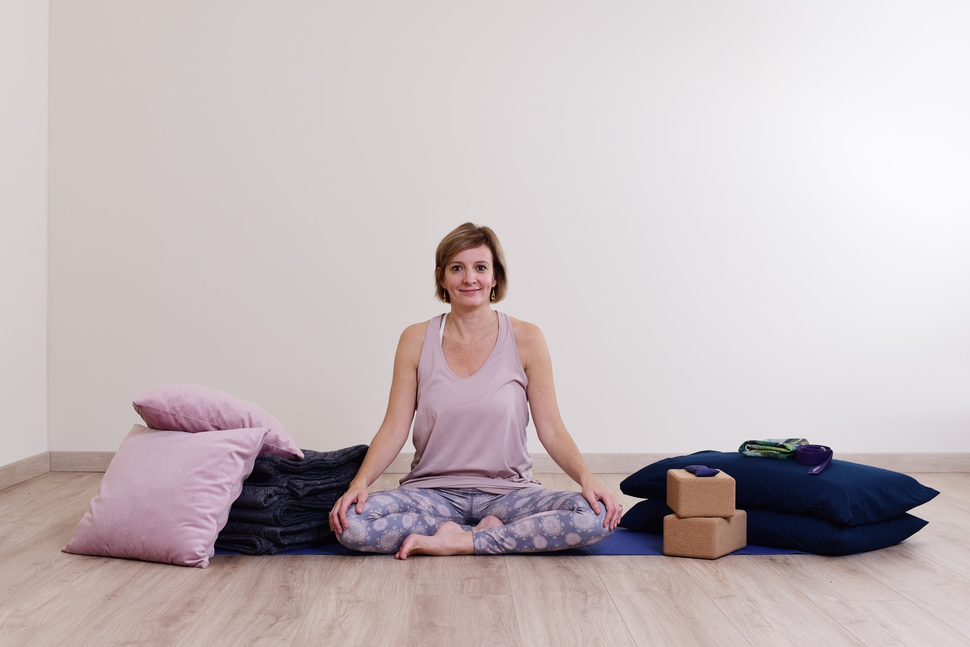 Audrey Favreau seated in her Restorative Yoga teaching space